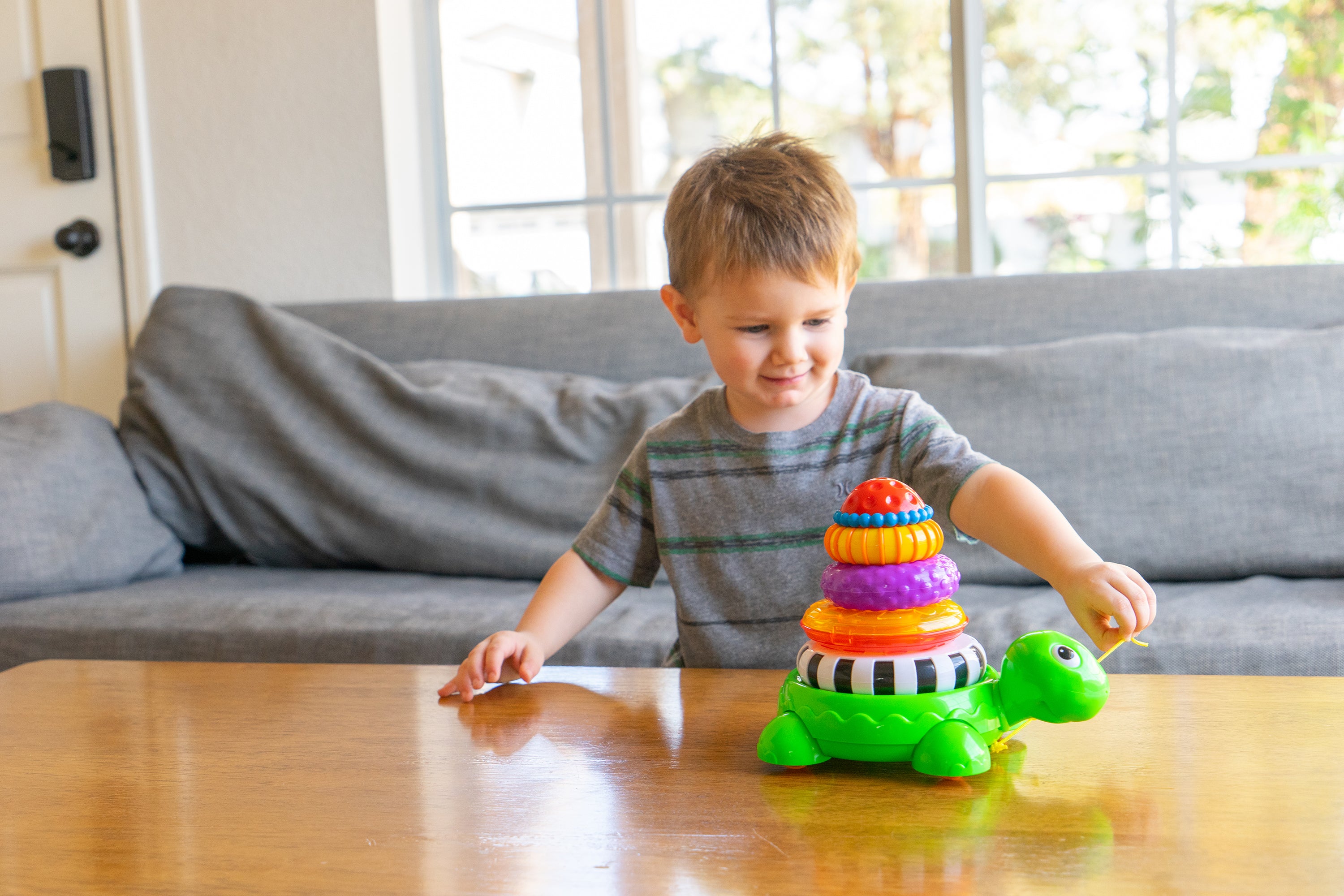 young boy pulling stacking turtle